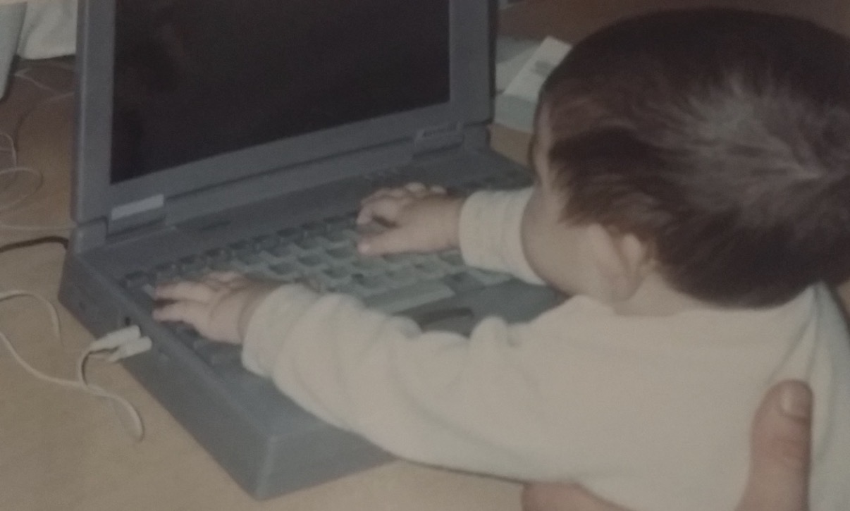 Alejandro as a child exploring a laptop
